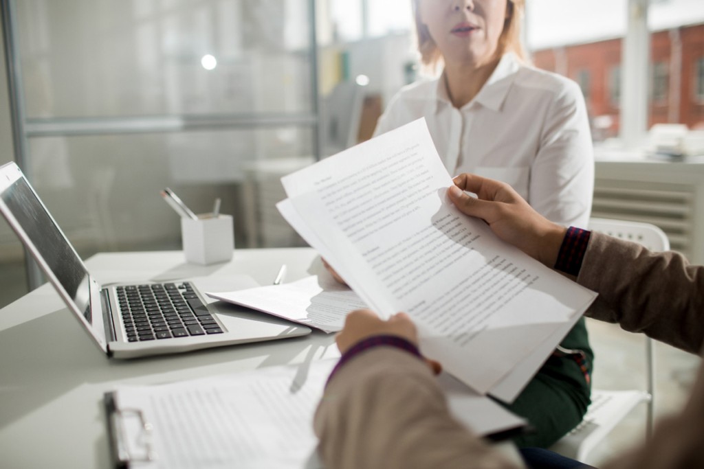 Business contract in male hands with woman sitting in the background