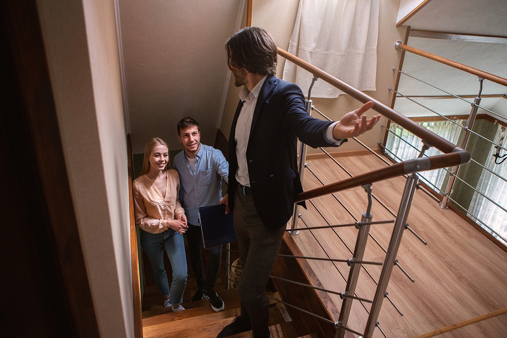 Real estate agent showing prospective buyers around property, panorama