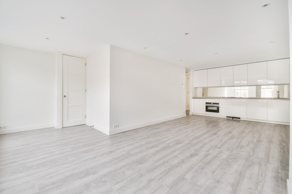 Interior of empty home kitchen with contemporary appliances. A large studio apartment with kitchen and white walls