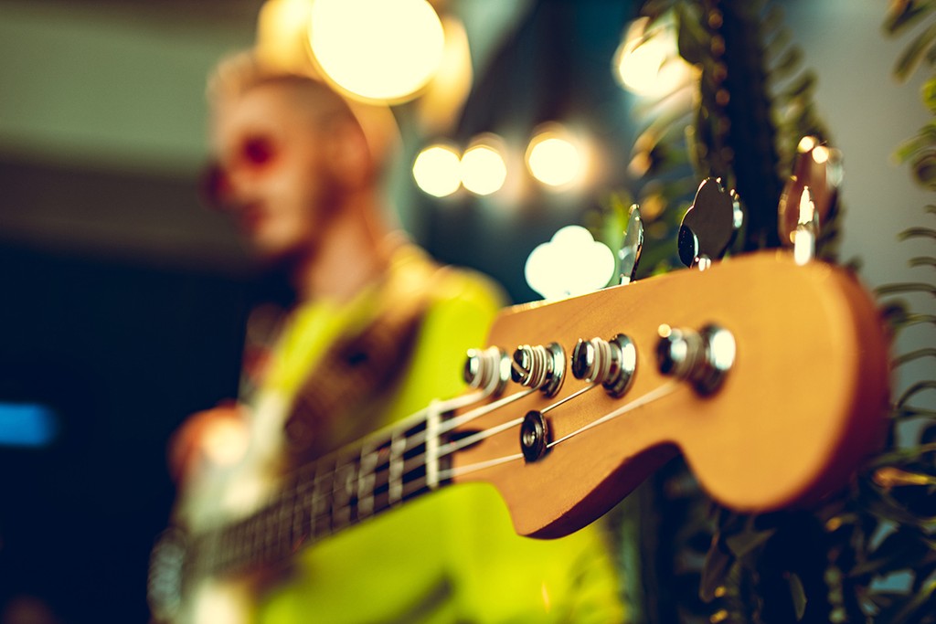 Guitar head with .ring gear on blurred guitarist body background