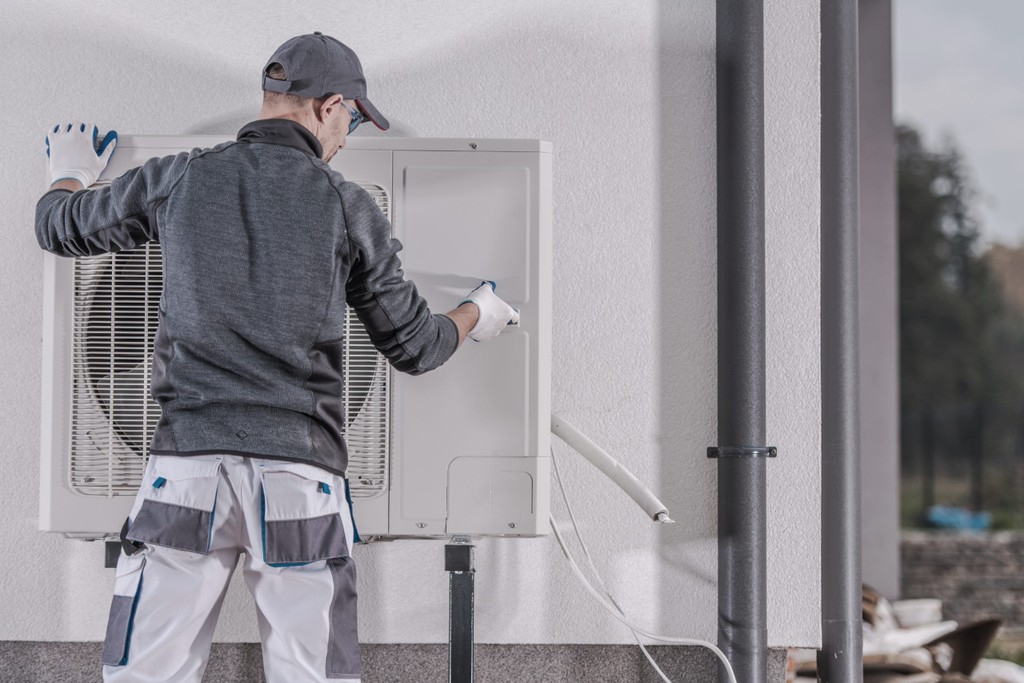 heat pump being installed by engineer outside a home