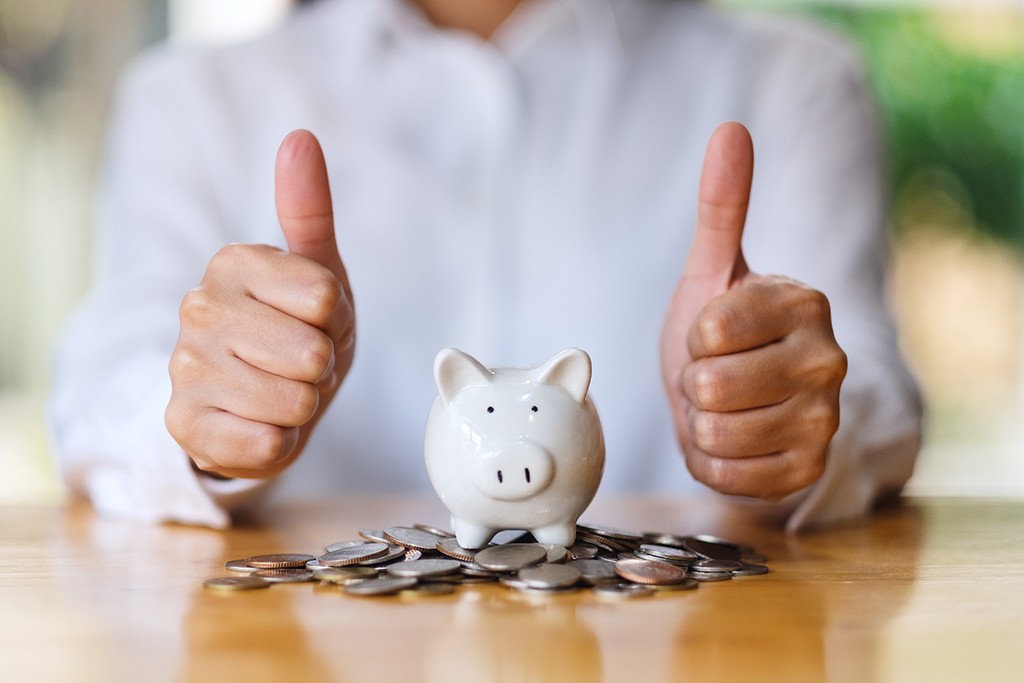 piggybank with coins and a thumbs up