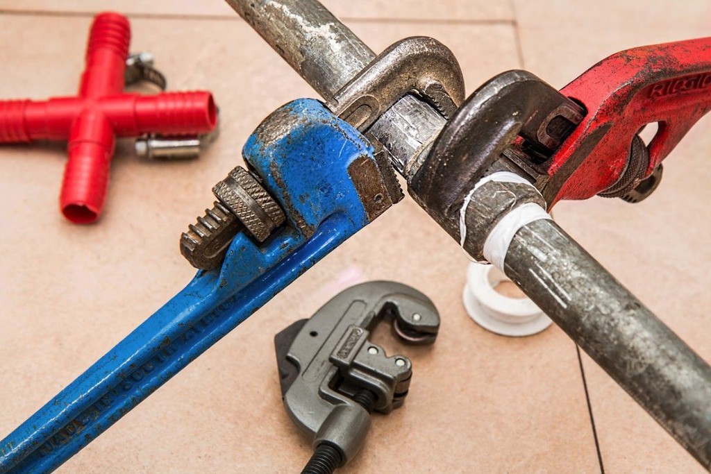 red and blue wrenches fixed to a pipe