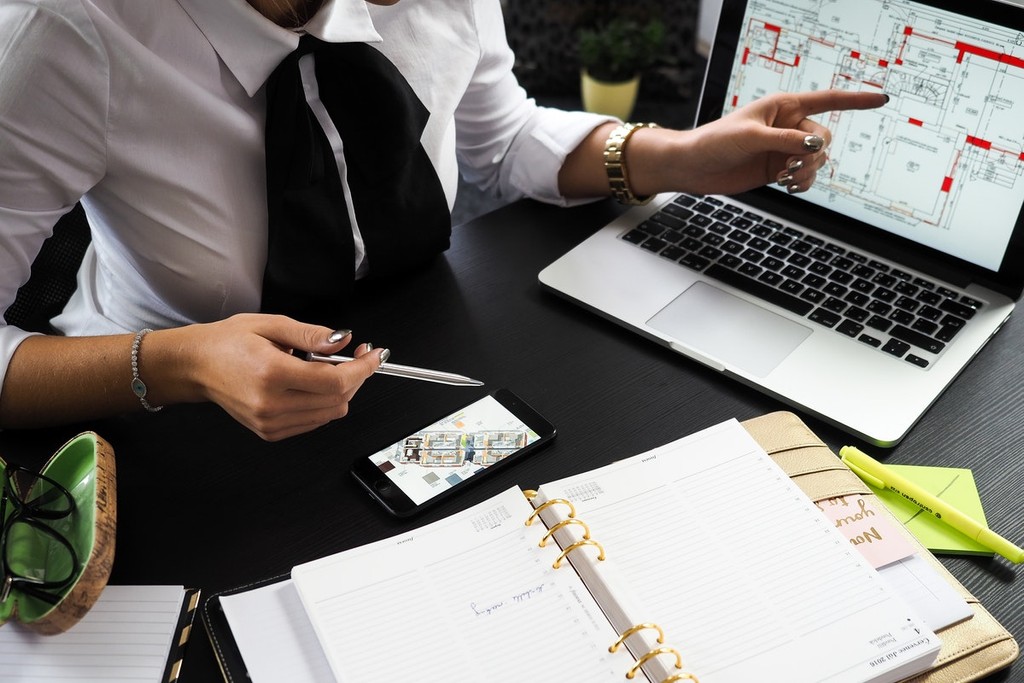 woman looking at a build design with folder and phone