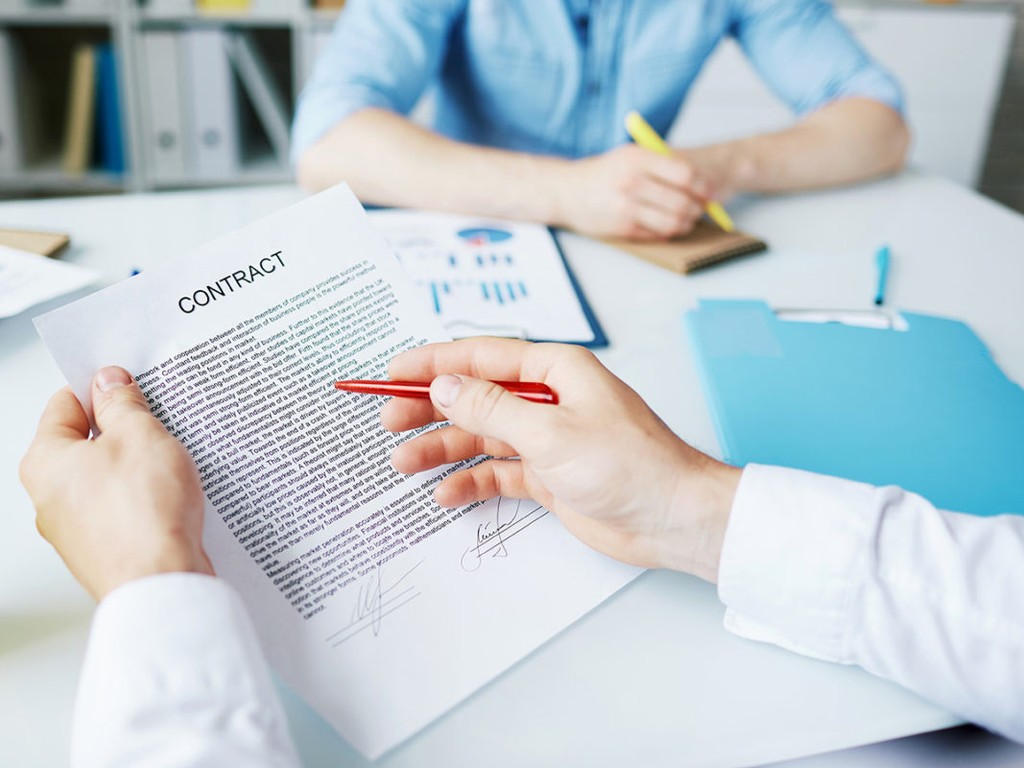 Businessman with pen reading text of contract