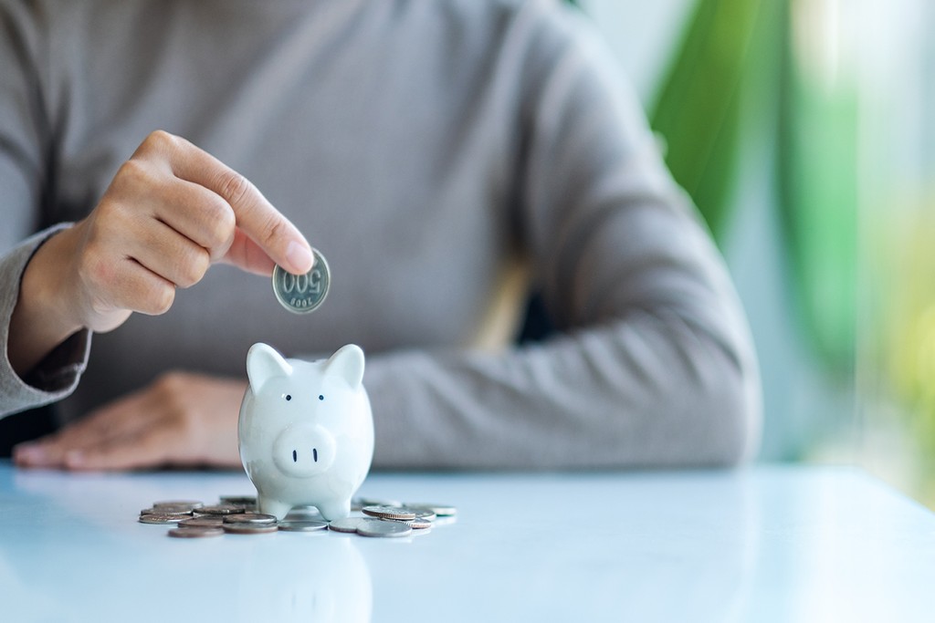 coin being placed into a piggy bank