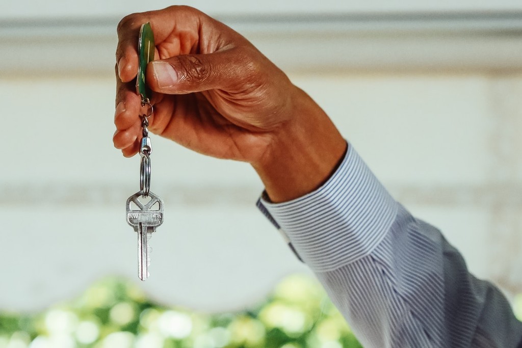 hand holding a pair of keys for their tenants