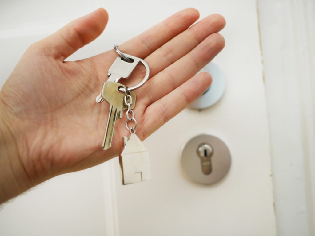 keys held by tenant in front of the door of a new home