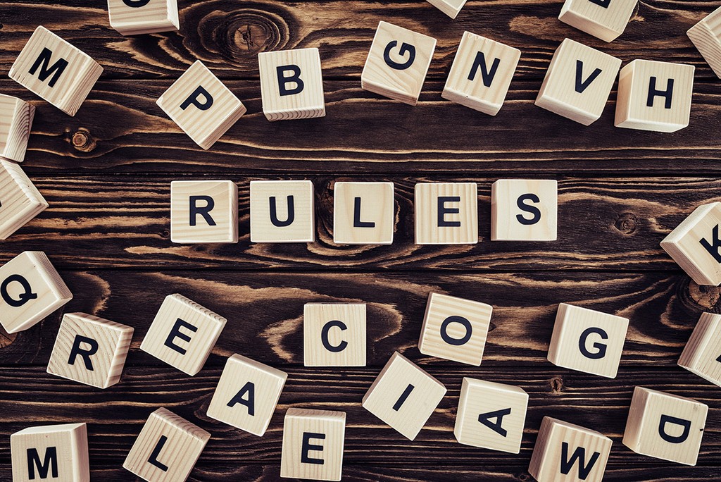 top view of rules word made of wooden blocks on brown surface