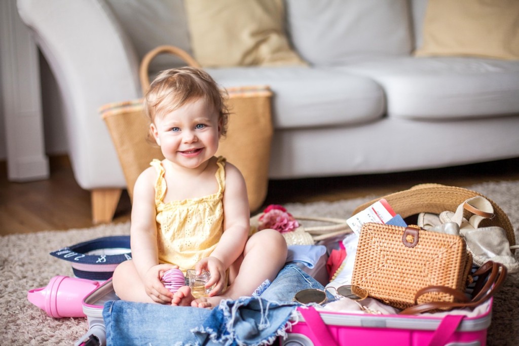 baby sitting on the floor in front of grey sofa