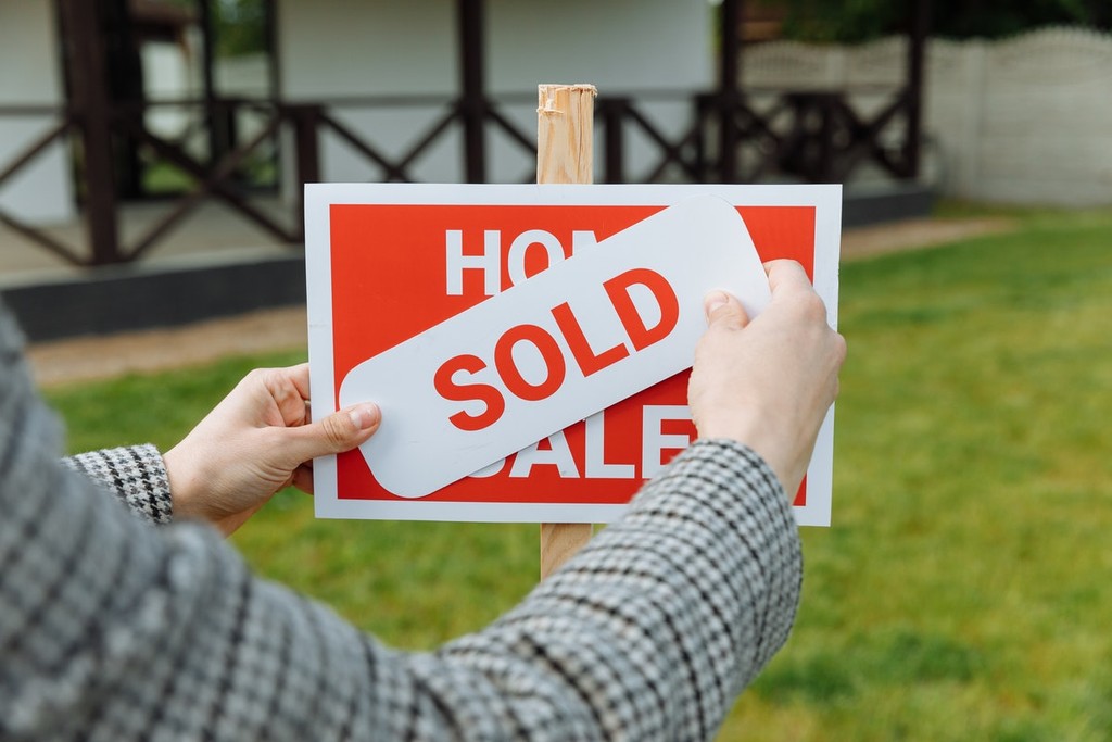 sold sign outside a house in the grass