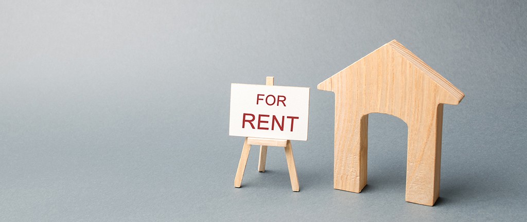 Wooden house and a poster with the inscription for rent. The concept of renting a house or apartment for rent. Rent a property. Rental Yield