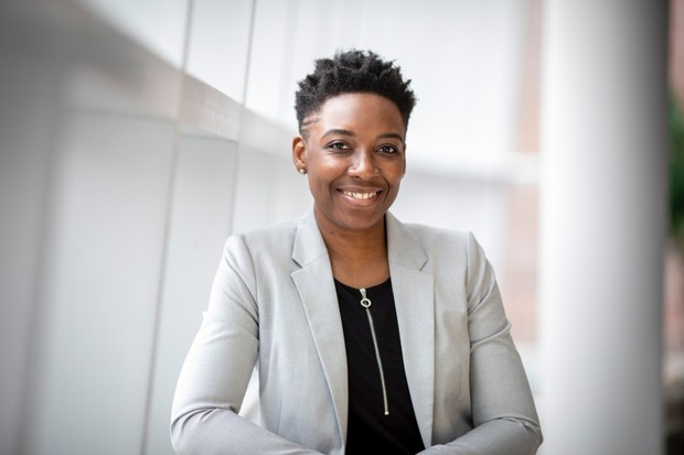 A smartly-dressed property manager is smiling at the camera 