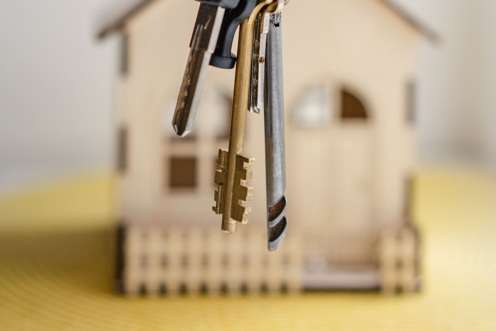 house keys dangling in front of a wooden house