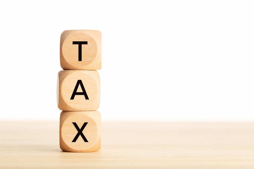 Tax word in wooden blocks on table. Taxation concept. White background Copy space