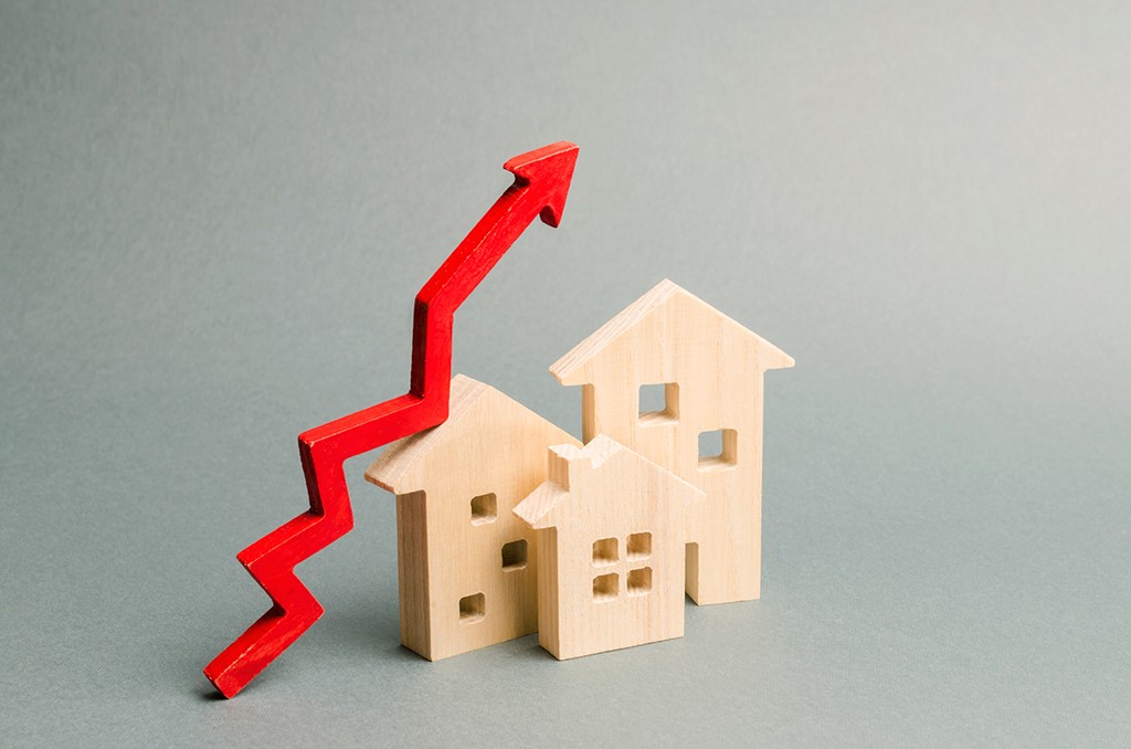 wooden houses with a graph line that signifies increase in house prices