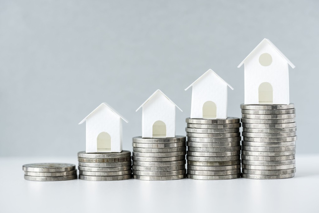 paper houses sat on coins increasing in size