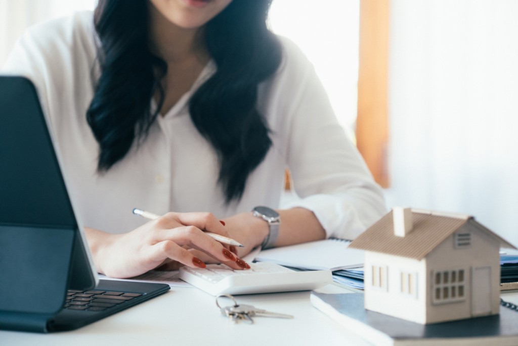 Woman calculating the cost of buy to let mortgage and completing paperwork