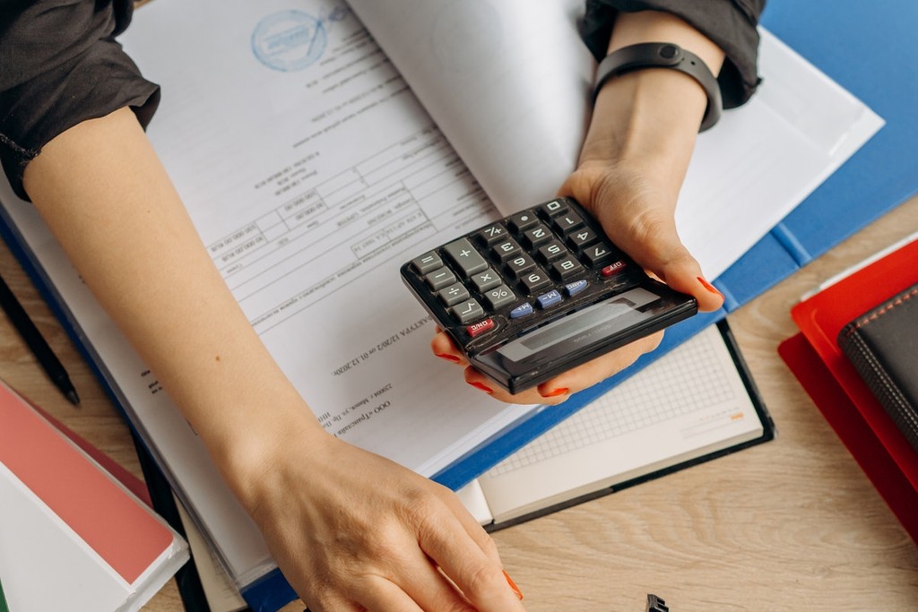 papers in a folder and a calculator being used