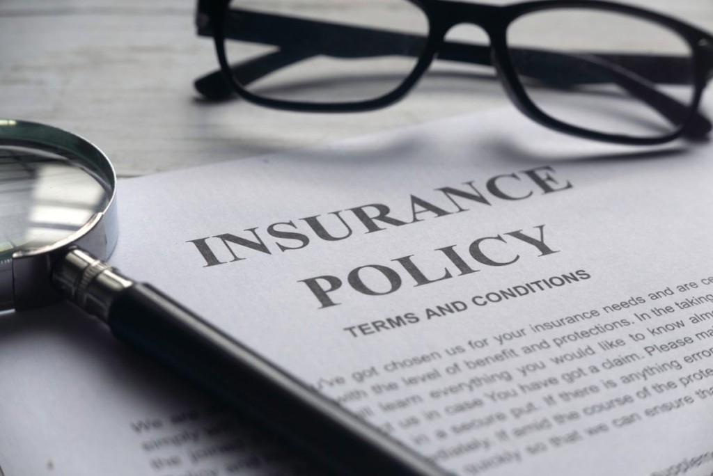 insurance policy document with glasses on paper 