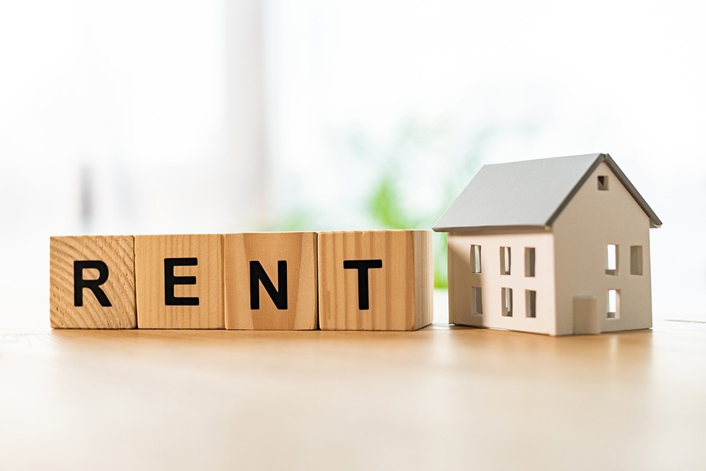 house model near cubes with rent lettering on wooden table