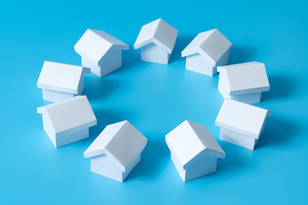 3D white houses model in circle on blue background for real estate property, housing development or community