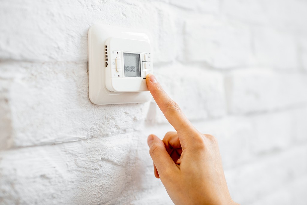 pressing a button on the thermostat