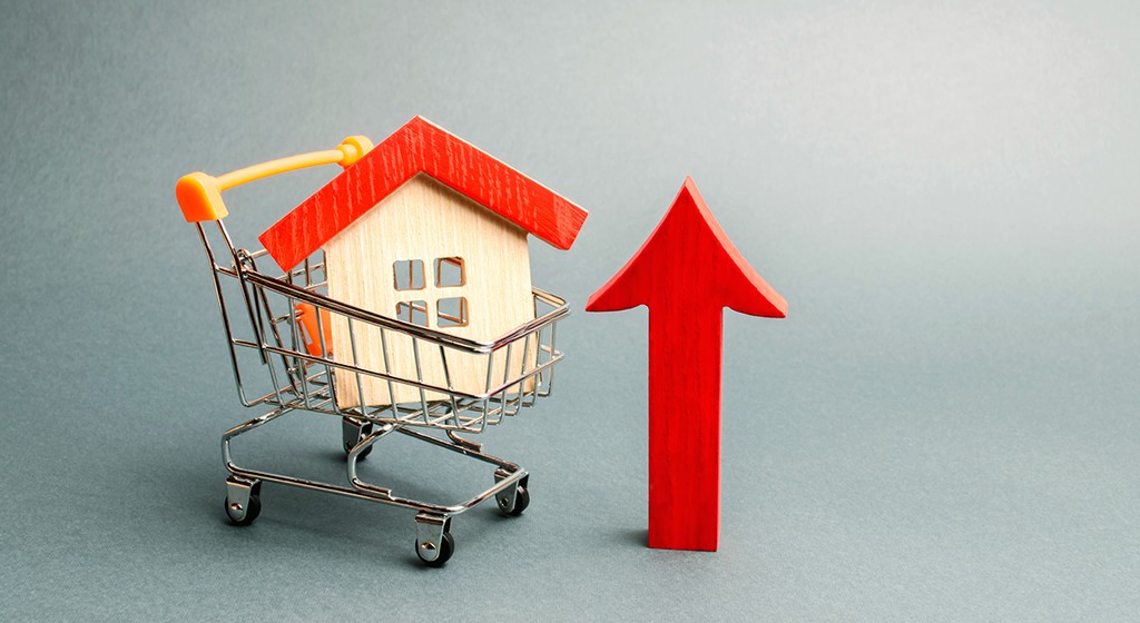 wooden house in a shopping cart with a red arrow next to it - buy-to-let mortgage concept