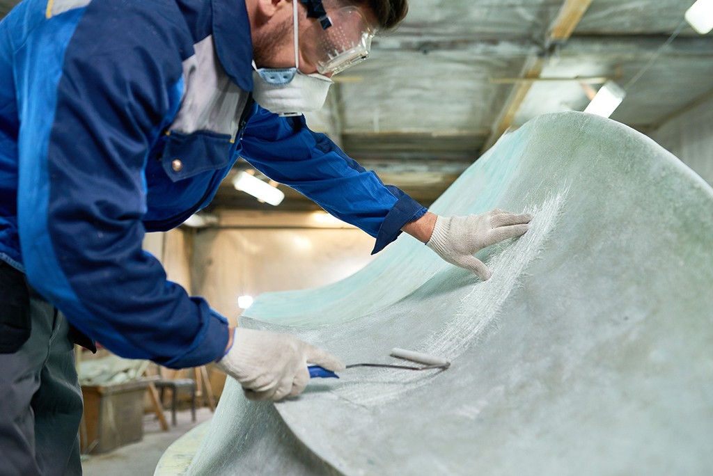 Man conducting property maintenance in blue overalls