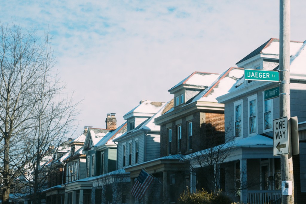 row of houses along a street against a blue sky