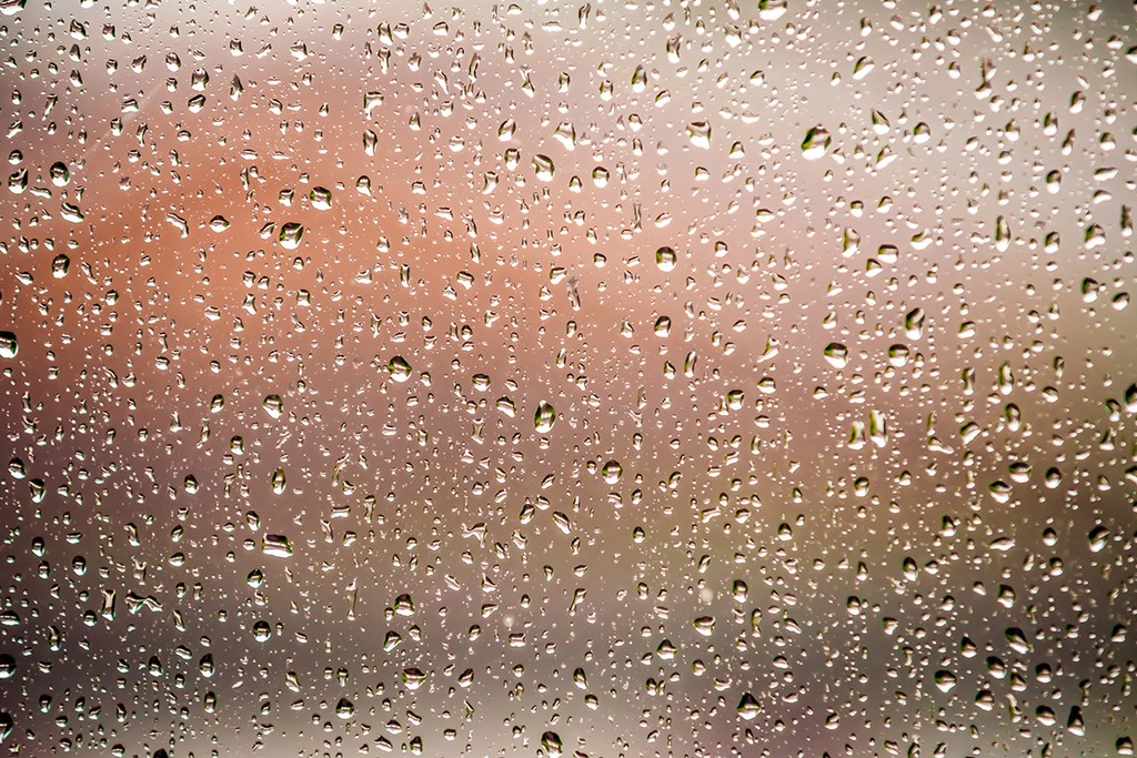 condensation on a window pane against an orange background