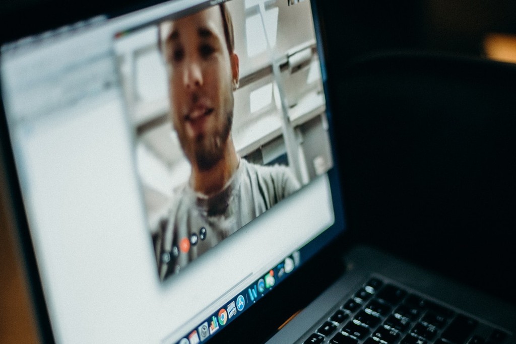 male on a webcam displayed on laptop