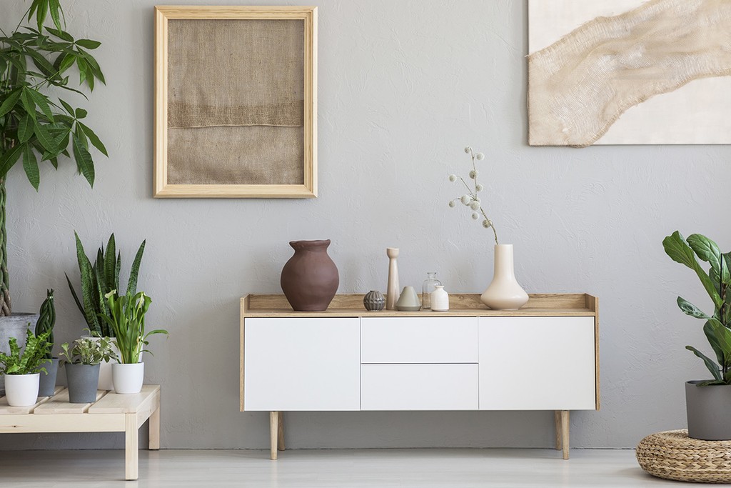 a home space with a table, vase and paintings