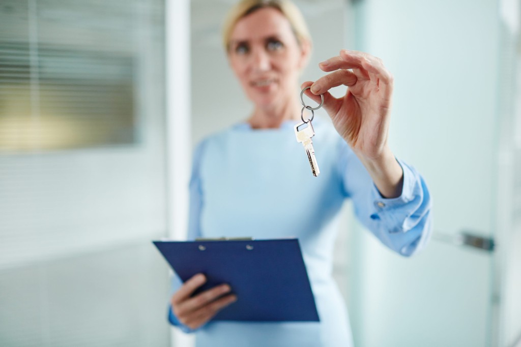 keys held by a woman in a blue dress