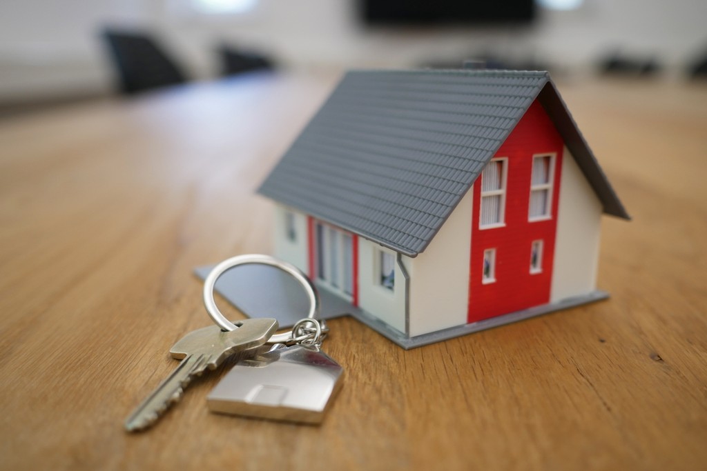 model of house with keys on a wooden table