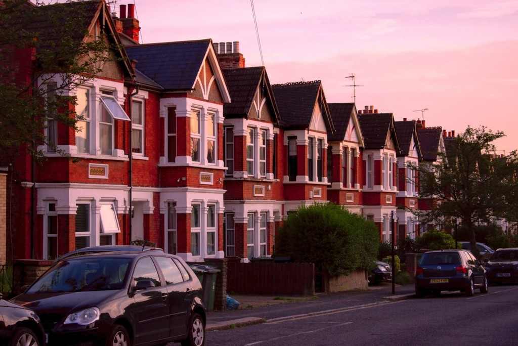 Row of terraced houses with orange and white brickwork at sunset