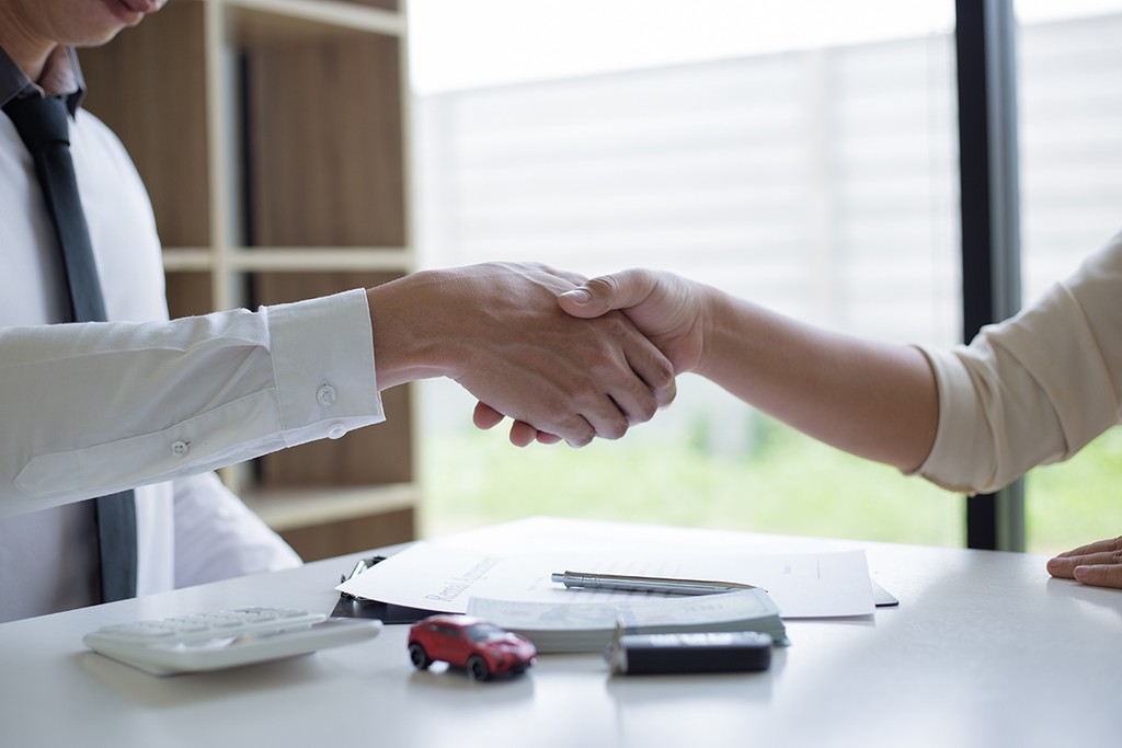 man and woman in white shirts shaking hands 