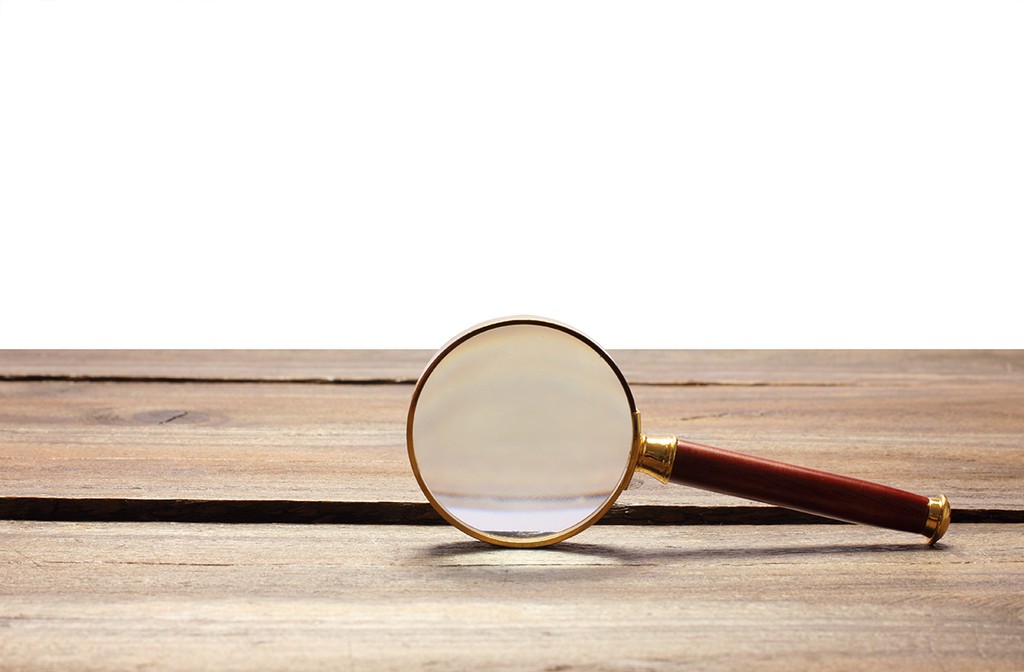 Magnifying Glass on Wooden Background