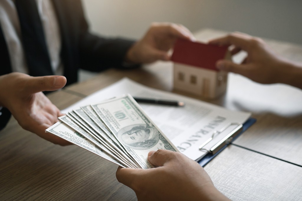 man exchanging money for a house 